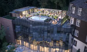 Nowoczesny taras z basenem i leżakami przy hotelu Sanssouci Karpacz. Goście relaksują się w otoczeniu zieleni.