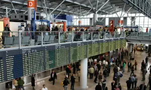 Lotnisko Chopina: tablice pokazują opóźnienia odlotów. Pasażerowie czekają na informacje.