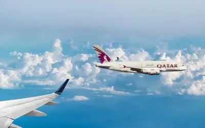 Dwa samoloty pasażerskie lecą nad chmurami. Jeden z nich, z logo Qatar Airways, osiąga średnią prędkość samolotu pasażerskiego.