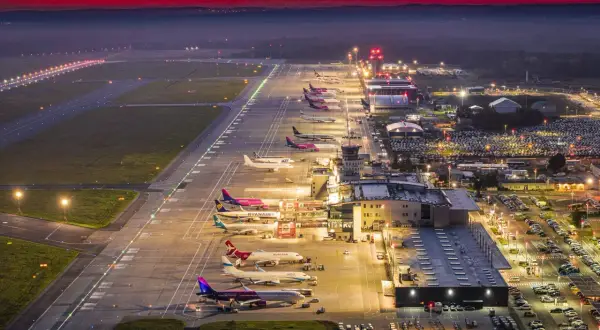 Lotnisko Katowice nocą, samoloty czekają na pasie startowym. Zastanawiasz się, ile trwa lot z Katowic do Marsa Alam?