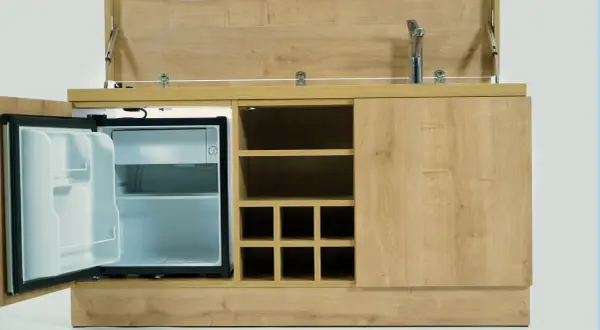 Hotelowy minibar z otwartą lodówką i miejscem na butelki. Zastanawiasz się, czy za minibar w hotelu się płaci?