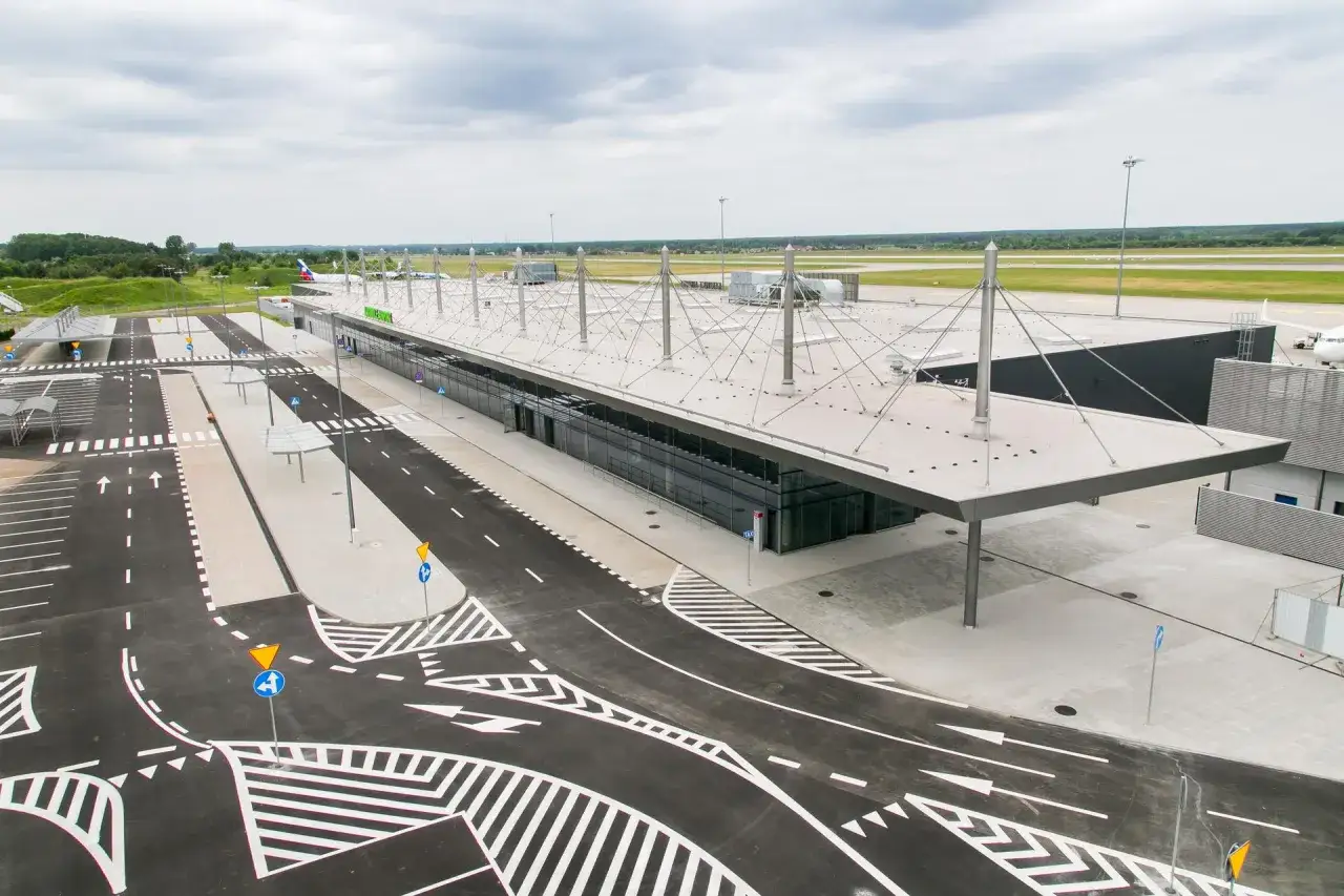 Nowoczesny terminal lotniska Katowice Pyrzowice z drogami manewrowymi i parkingiem.