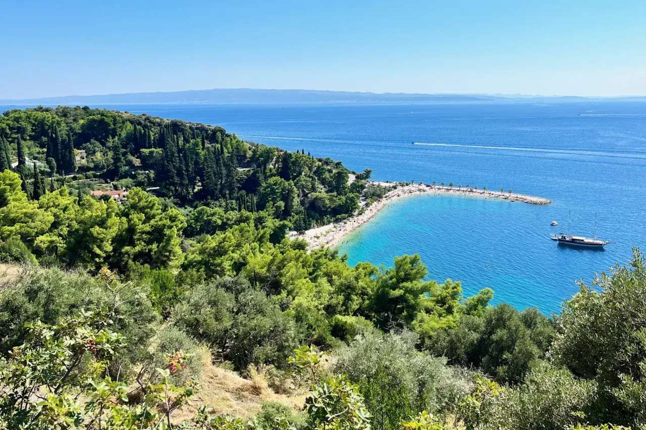 Widok na zatokę z plażą i łodzią. Wspaniałe Split Chorwacja atrakcje przyciągają turystów.