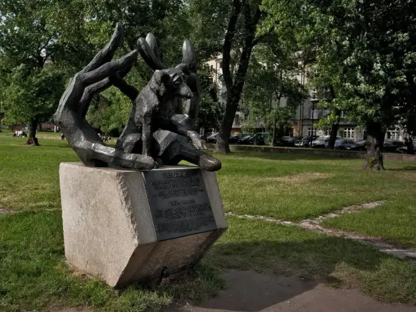 Pomnik psa Dżoka, wiernego towarzysza, siedzi w dłoniach, symbolizując oddanie i miłość.